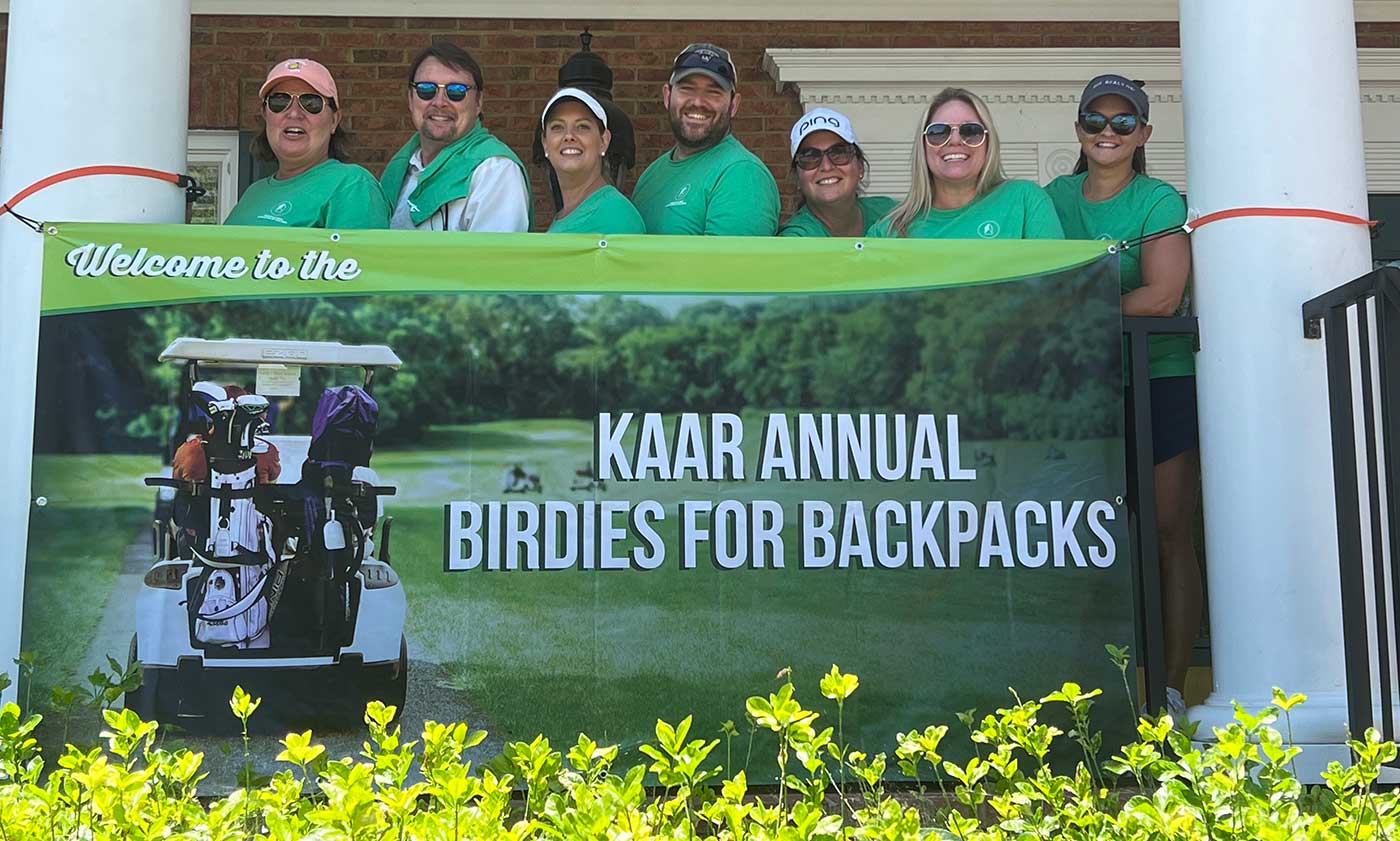 KAAR-Annual-Birdies-for-Backpacks-2022 Golf tournament participants with Knoxville Area Association of Realtors banner