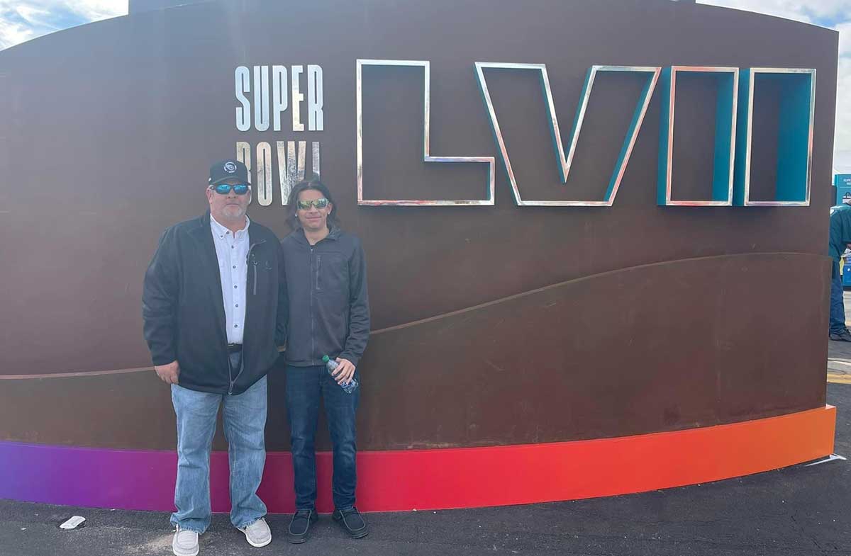 Max-and-Kevin_SB Max in front of the Super Bowl sign