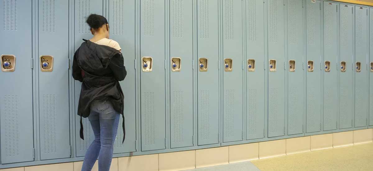 chalkbeat.brightspotcdn A student at her locker in a hallway at North-Grand High School in Chicago. Dropout rates have gone up in some areas amid COVID.