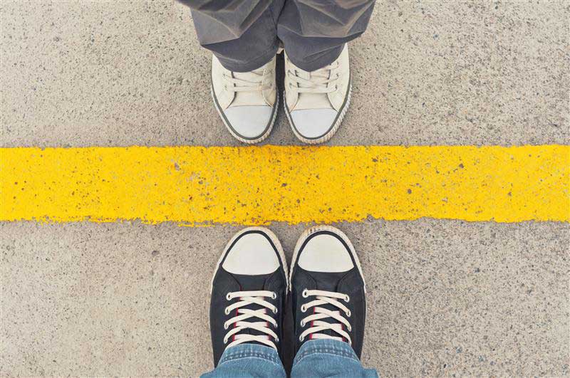 How-to-teach-teens-healthy-boundaries- photo of two pairs of shoes on each side of a yellow line facing each other