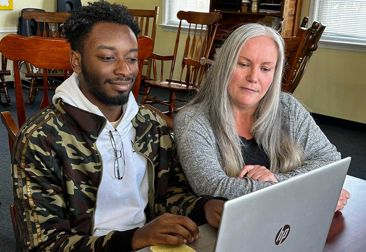 Niziere-with-specialist-Christine Niziere and his specialist working from a laptop