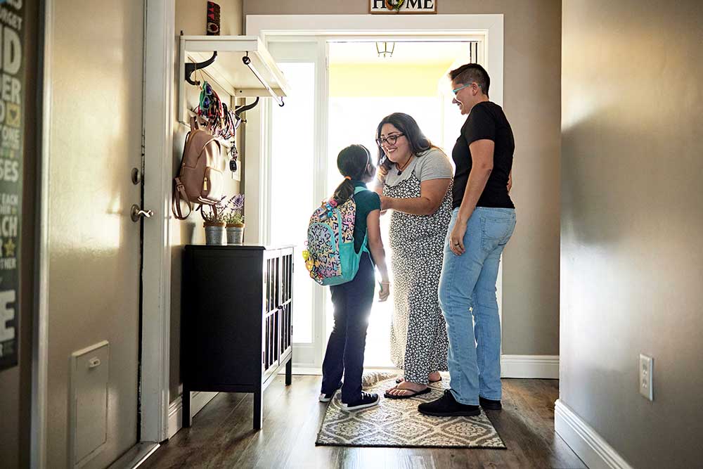 Parents-getting-daughter-ready-to-leave-for-school Parents get daughter ready to leave for school at home doorway