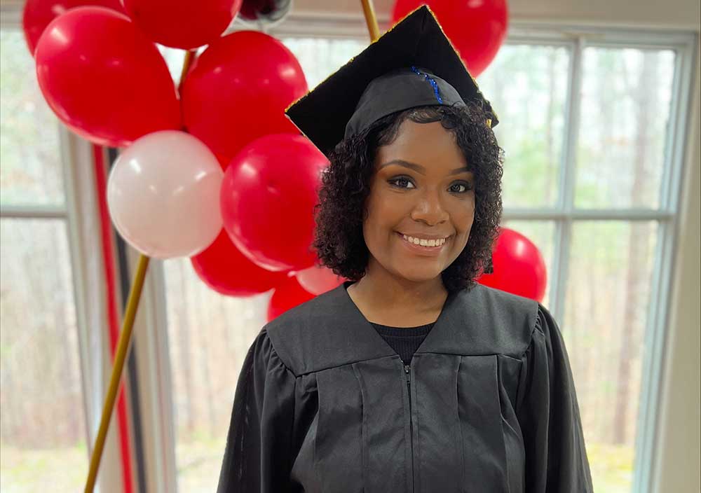 Tione-Cap-and-Gown- LifeSet participant, Tione in her graduation cap and gown