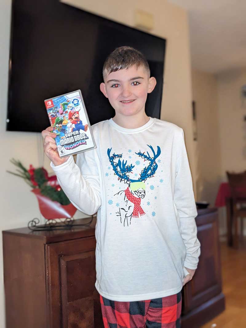 Youth-with-video-game-gift-from-Holiday-Heroes male youth with video game gift from Holiday Heroes