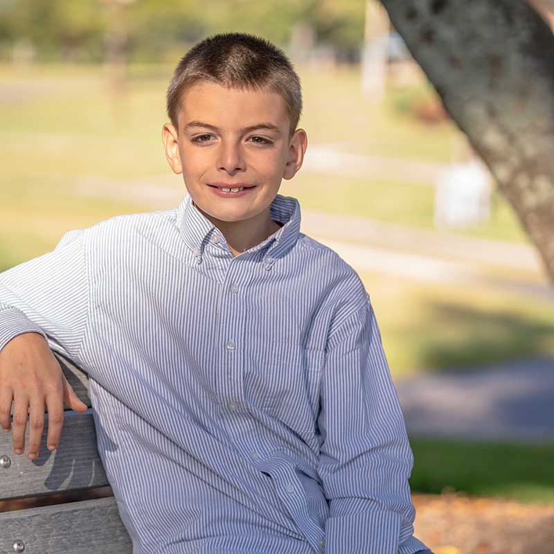 Braiden-02 portrait of Braiden sitting on a bench