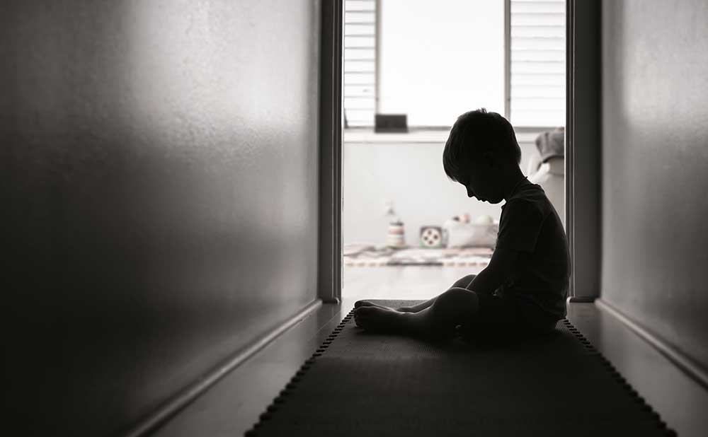 young-child-sitting-in-a-dark-hallway young child sitting in a dark hallway