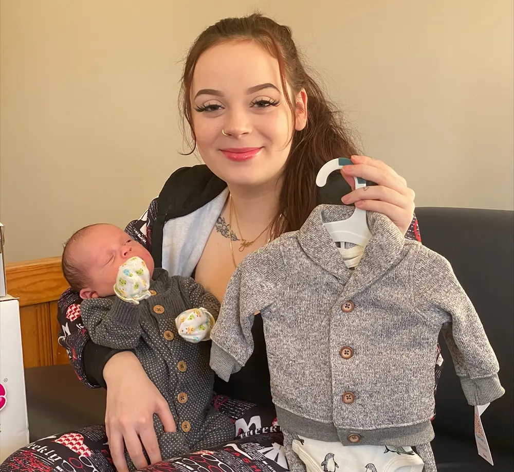Riley_Holiday Heroes LifeSet participant with her newborn and clothes supported by Holiday Heroes