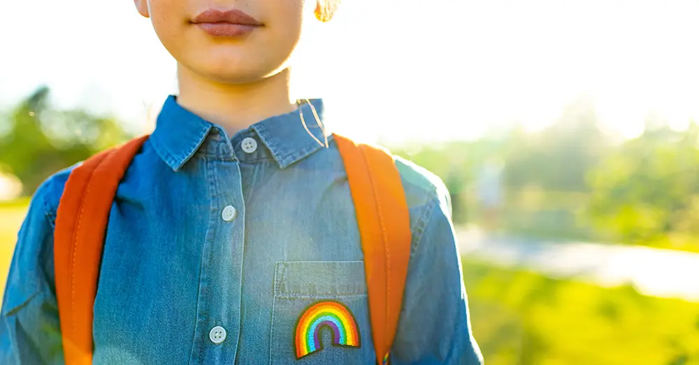kid wearing backpack with rainbow patch kid wearing backpack with rainbow patch