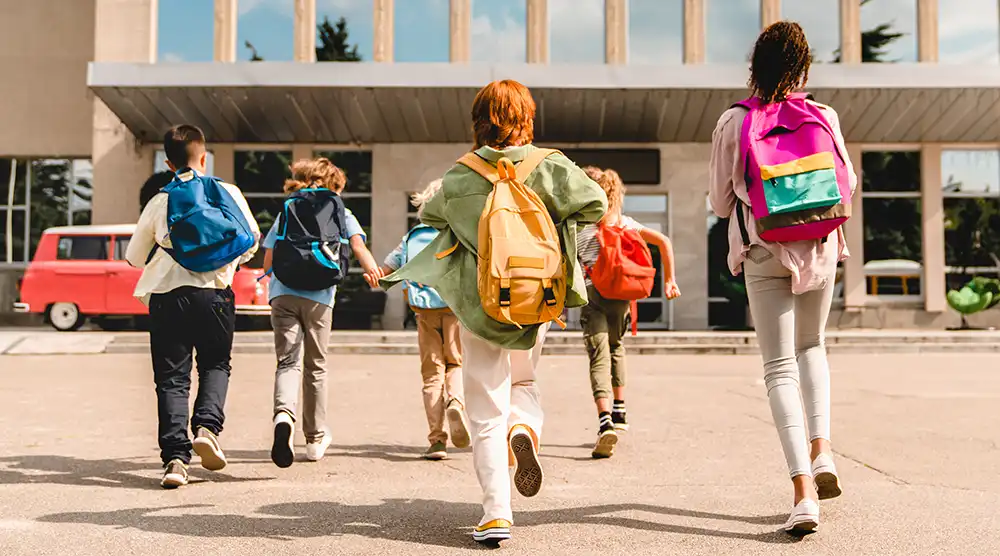 kids with backpacks walking into school kids with backpacks walking into school