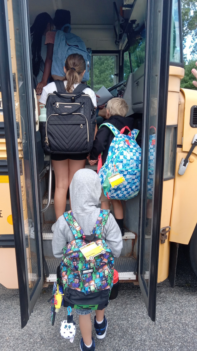 Kids getting on bus with backpacks kids getting on school bus