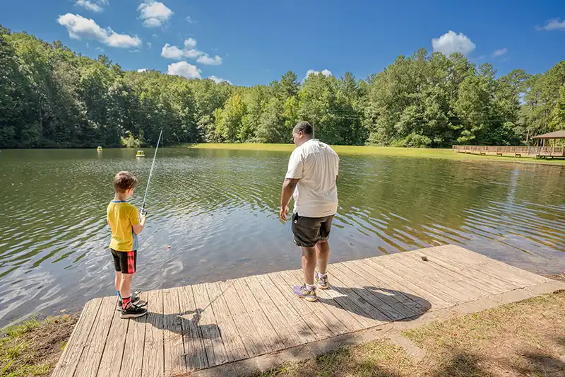 adult-and-young-boy-fishing adult teaching young boy how to fish