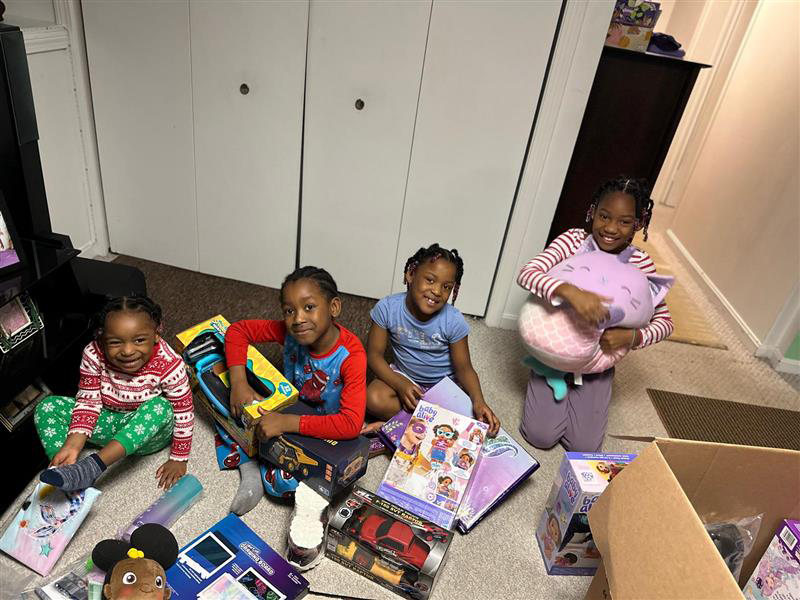 Holiday-heroes-family young kids opening Holiday Heroes Christmas gifts