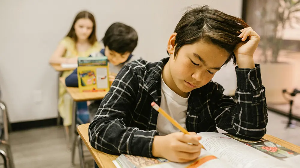 7-waus-to-overcome-stress young kid in class writing